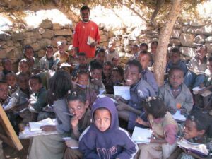 A crowded group of Ethiopian school children in an open air classroom
