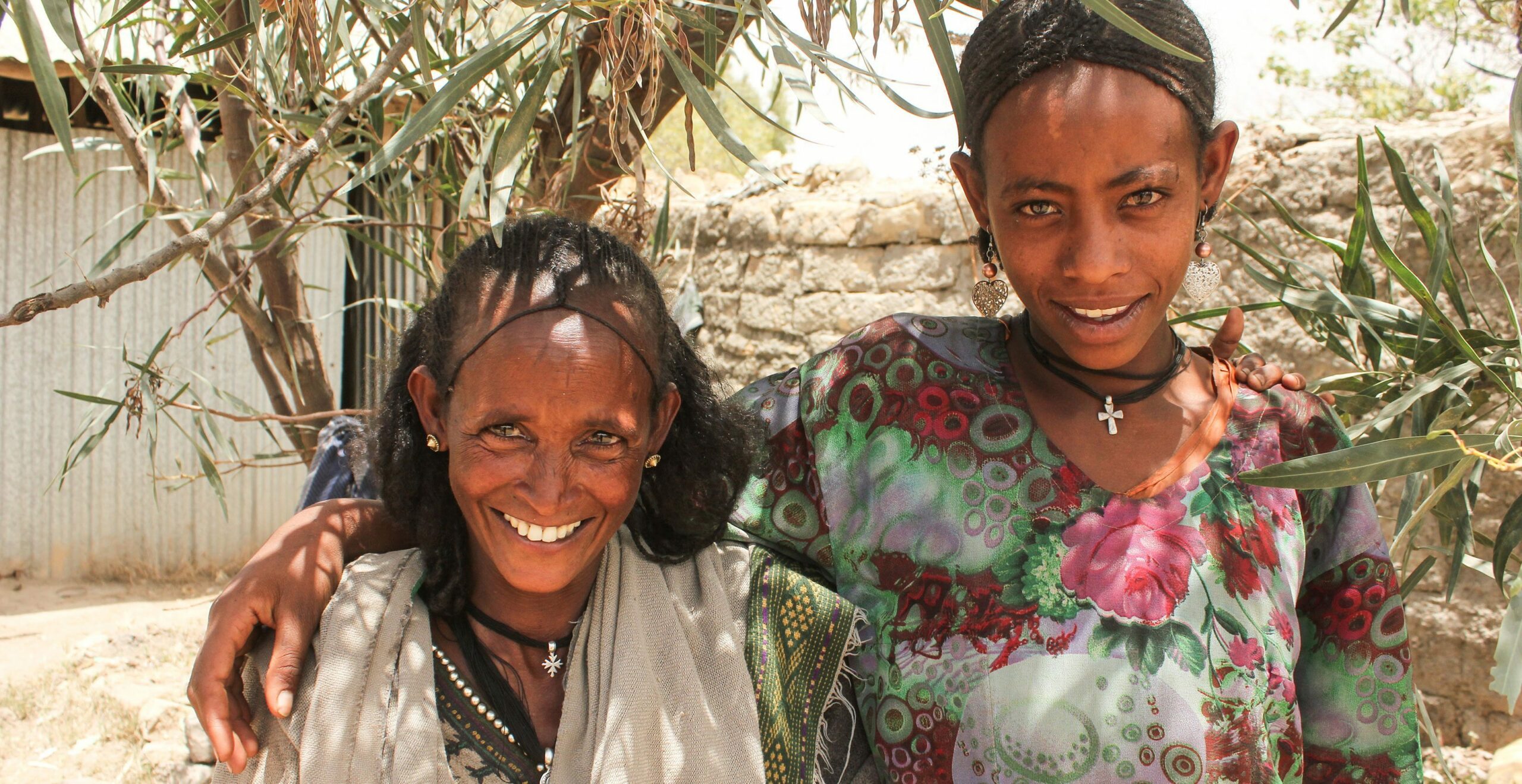 Two Ethiopian women smiling underneath a tree
